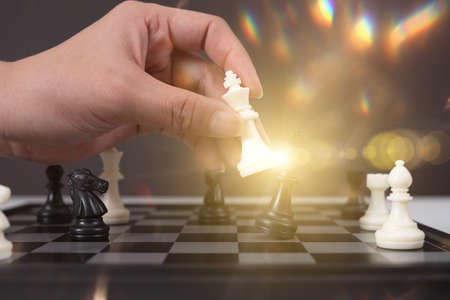 hand of businessman moving chess game figure in competition success play. strategy, management or leadership conceptの写真素材