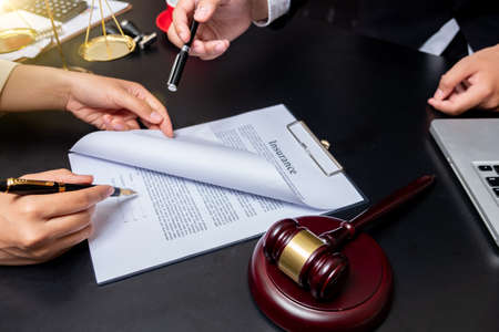 lawyer Detail of a judge sitting at his desk, studying new laws and legislation and taking notes. Selective focus.の写真素材