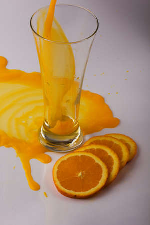 Orange juice into a glass and orange slicesの写真素材