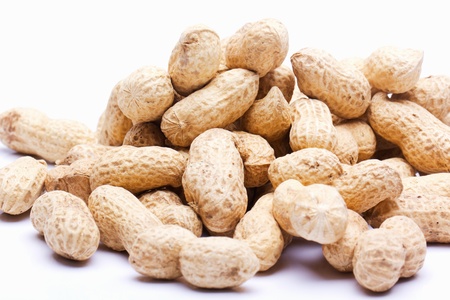 raw peanuts with skin on a white background