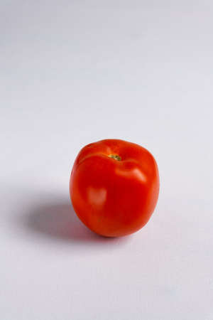 One red tomato on a white background. Close-up, selective focusの写真素材