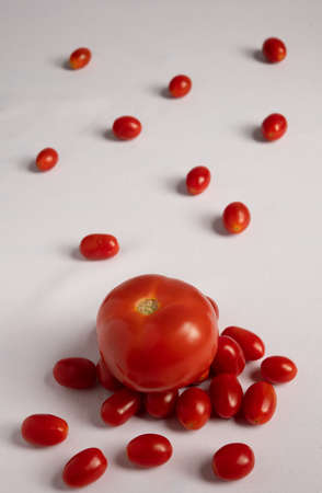 Red tomatoes and cherry tomatoes on a white background. The concept of healthy eating.の写真素材