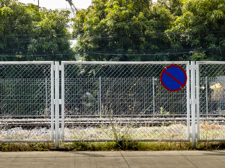 No parking traffic sign with wire mesh fence 