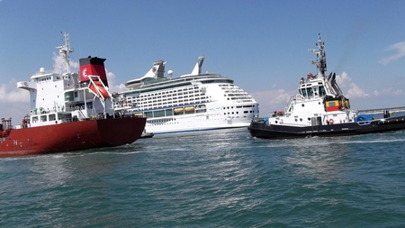 pilot accompanies a tanker in port on the background of a cruise shipのeditorial素材