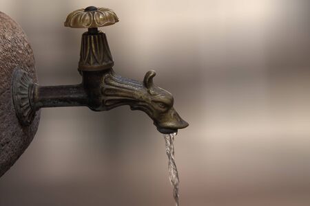 vintage, antique faucet from which water flowingの写真素材