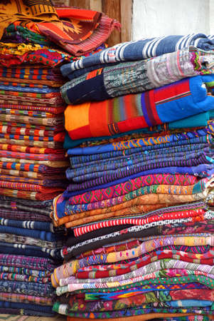 Handmade linens of different patterns and sizes on the street for market stacked in a doorway.の写真素材