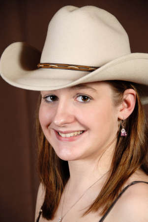 Happy cowgirl smiling and looking at camera in studio.の写真素材