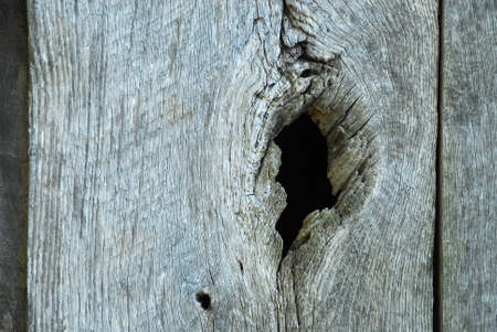 Knot hole in old barn wood. Seeing into the darkness.の写真素材