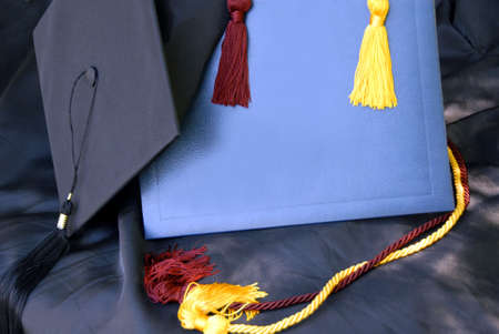 Display of graduation cap and gown, mortar board, diploma cover, and tassels with room for your...