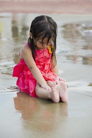 Children playing in a water park play ground in the city.の写真素材