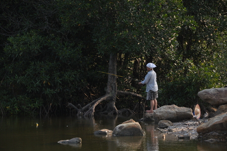 old lady fishing at the riversideの写真素材