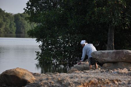 old lady fishing at the riversideの写真素材