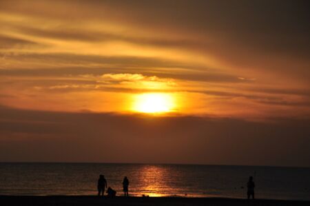 people playing beside the beach during sunsetの写真素材