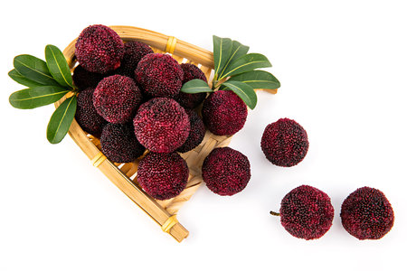 Lychee fruits in a basket isolated on a white background.