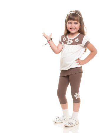 cute little girl posing in the studio and point to somewhere or holding something against white backgroundの写真素材