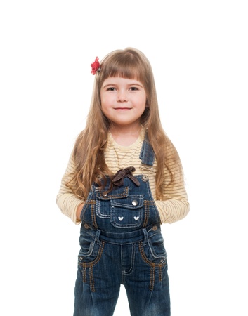 cute little girl wearing jeans overall posing in studio and smiling on white backgroundの写真素材