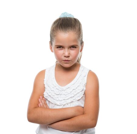 little girl standing and grins mischievously to the camera hands clasped in front of herの写真素材