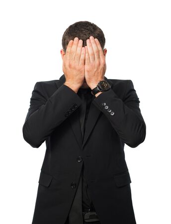 young man in black suit covers his face by palmsの写真素材