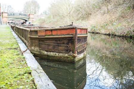 a old rusty metal canal barge moored on the canalの写真素材