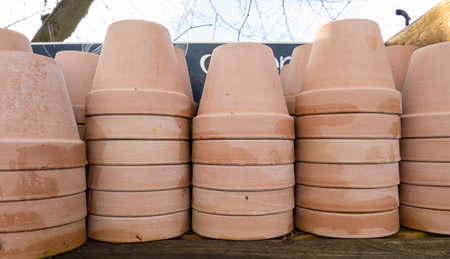 Stacks of various terracotta pots for plants for sale at a garden store.の写真素材