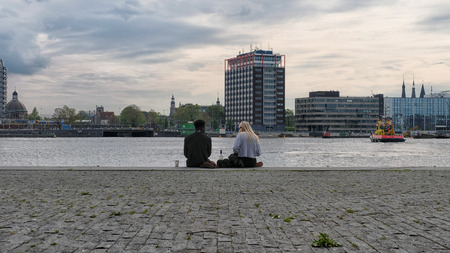 Amsterdam, The Netherlands - May 16, 2017. Young couple on the embankment of Amsterdamのeditorial素材