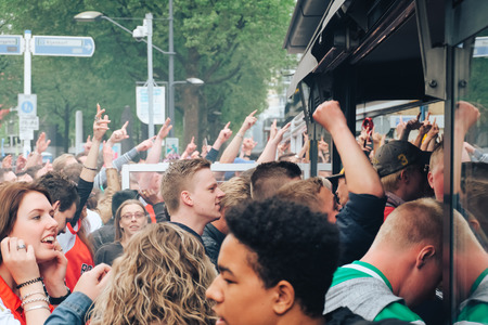 Rotterdam, The Netherlands - May 14, 2017 - a group of football fans watching the match on the street near the barのeditorial素材
