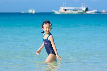 A Chinese little girl playing on the beachの写真素材