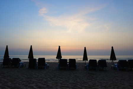 Beach landscape with a row of folded umbrella in Phuket Island, Thailandの写真素材