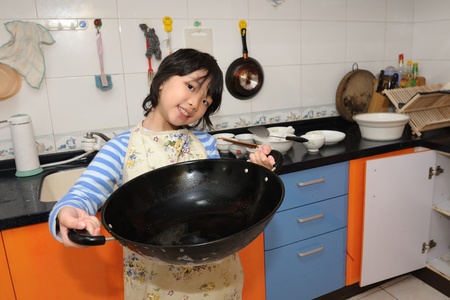 Asian kid do housework in the kitchenの写真素材