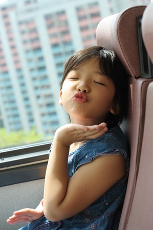 Asian happy little kid blowing a kiss in the busの写真素材