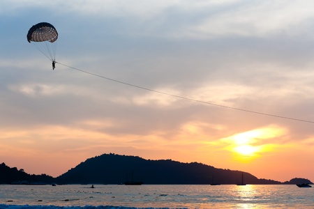 Parasailing under blue sky at sunsetの写真素材