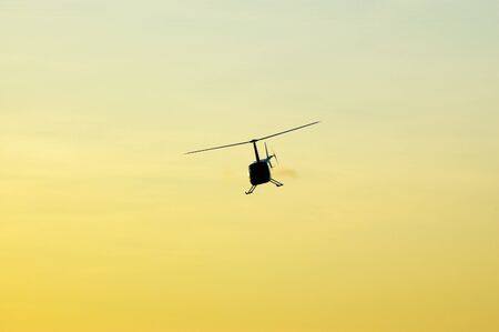 Helicopter flying over the sky at sunsetのeditorial素材
