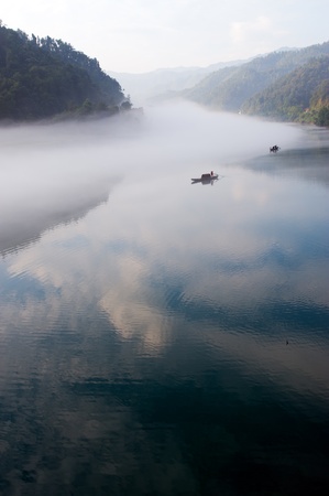 Fishing boat on the foggy river in Hunan province of Chinaの写真素材