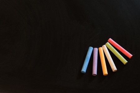 Blank chalkboard and group of colorful chalks