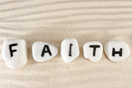 Faith word on group of stones with sand as backgroundの写真素材
