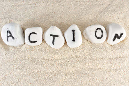 Action word on group of stones on the sandの写真素材