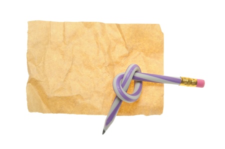 Twisted pencil on old paper isolated on white backgroundの写真素材