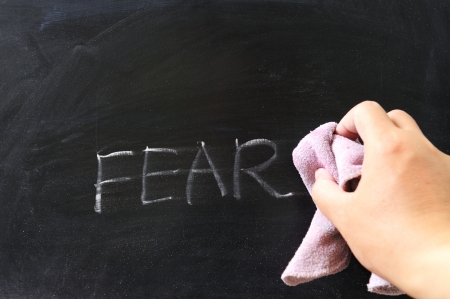 Hand wiping off fear word using rugの写真素材