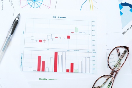 Business graph printed on white paper with pen and glassesの写真素材