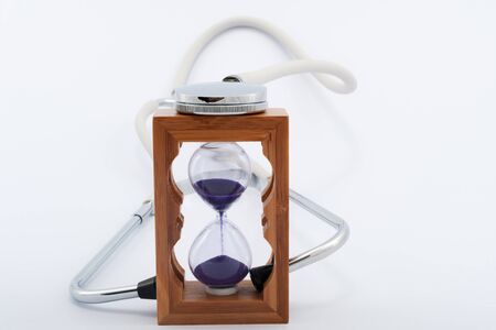 Using stethoscope with hourglass on white backgroundの写真素材