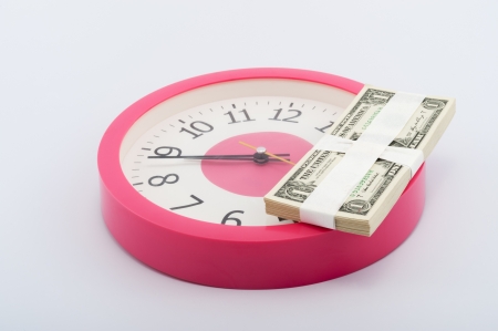 Clock and a stack of paper money on white backgroundの写真素材