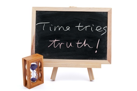 "Time tries truth" sayiings written on chalkboard with an hourglass beside itの写真素材