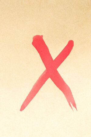 Cross mark symbol written on brown paper