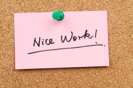 Nice work words written on paper and pinned on corkboardの写真素材
