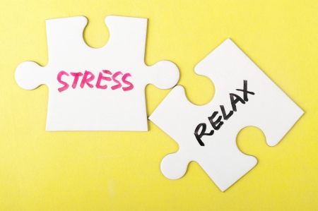 Stress and relax words written on two pieces of jigsaw puzzleの写真素材