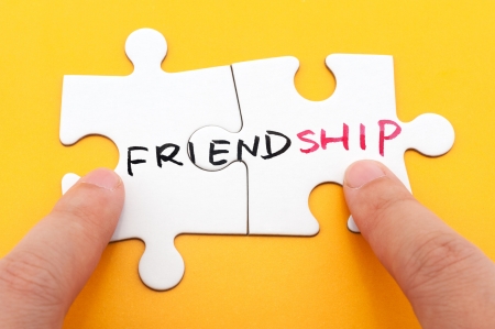 Friendship word written on two pieces of puzzleの写真素材