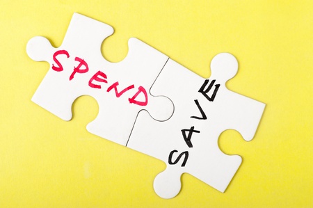 Spend and save words written on two pieces of puzzleの写真素材