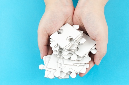 Hand holding piles of jigsaw puzzle pieces