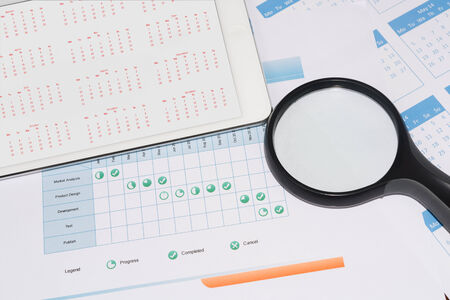 Project schedule with magnifier and calendar on the tablet screenの写真素材
