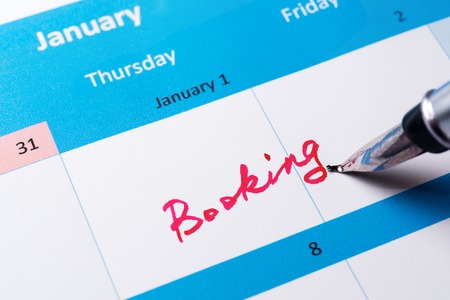 Booking word written on the calendar with a penの写真素材